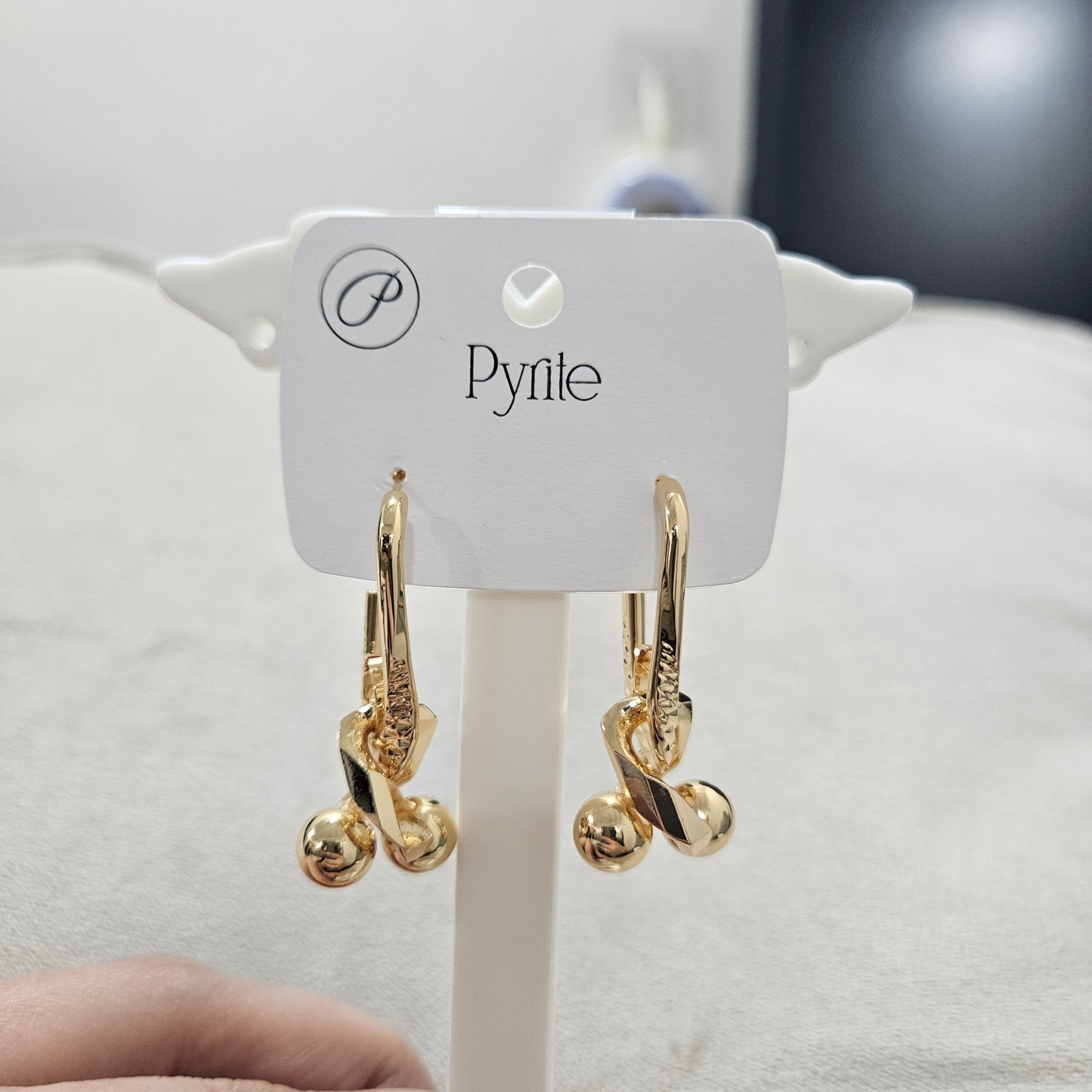 Angled view of anti-tarnish stainless steel abstract earrings showing the polished spheres and geometric link design