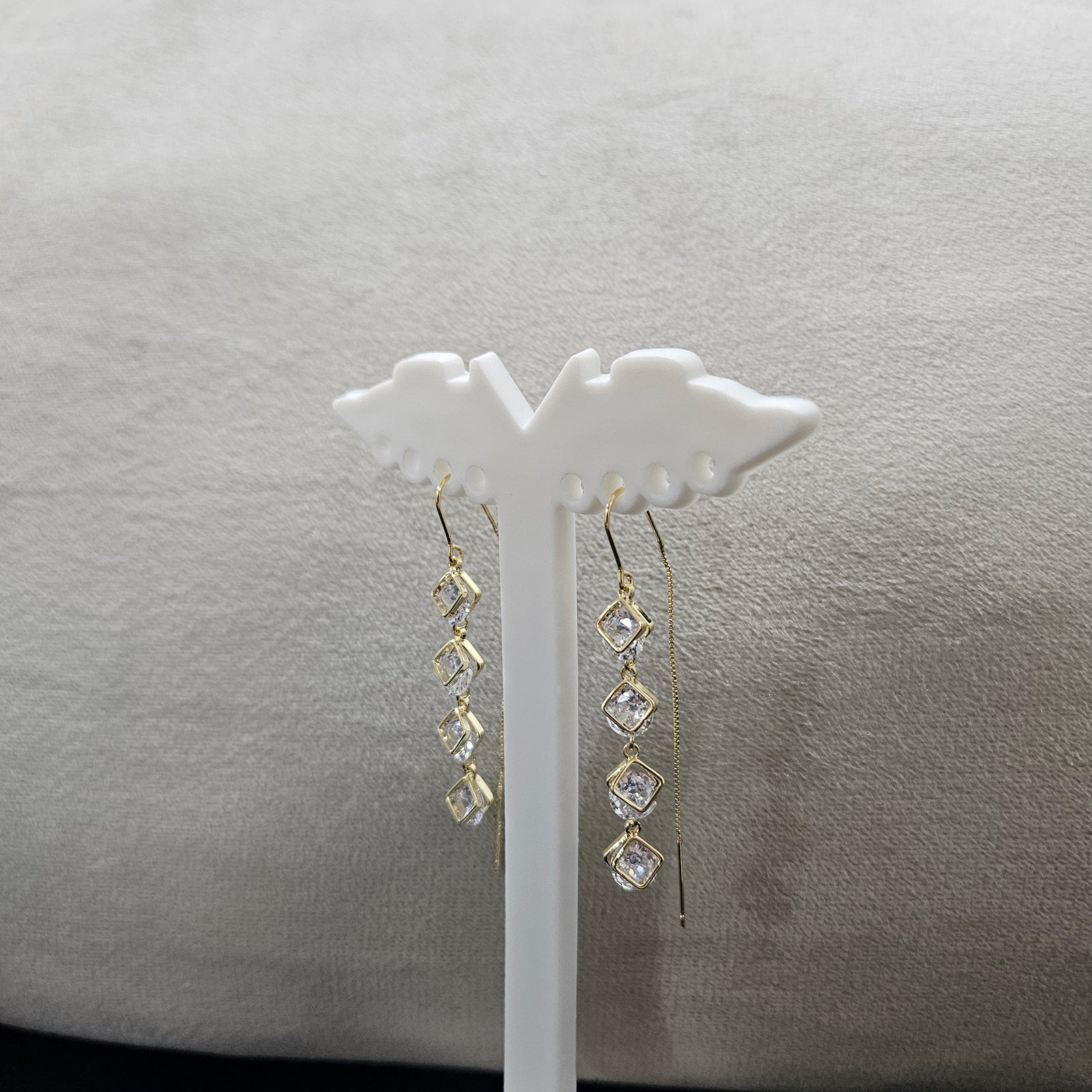 Detailed side view of anti-tarnish gold plated linear earrings featuring shimmering geometric square crystals