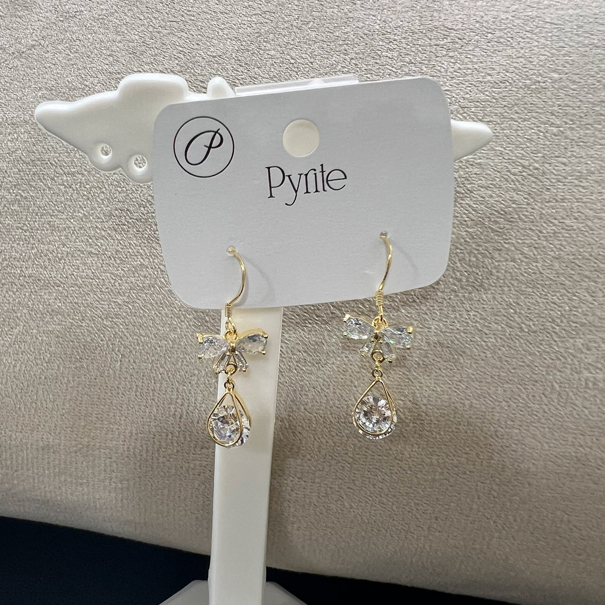 Close-up of tarnish-resistant stainless steel ribbon earrings featuring brilliant-cut stones and a polished finish