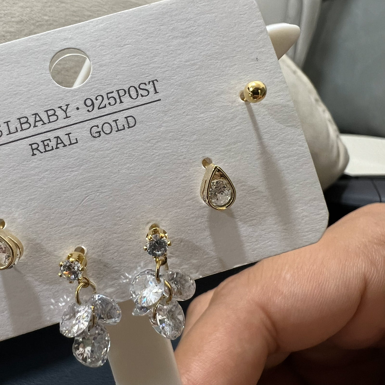 Detailed view of gold tone stainless steel earrings including teardrop crystals and dangling leaf clusters for women.