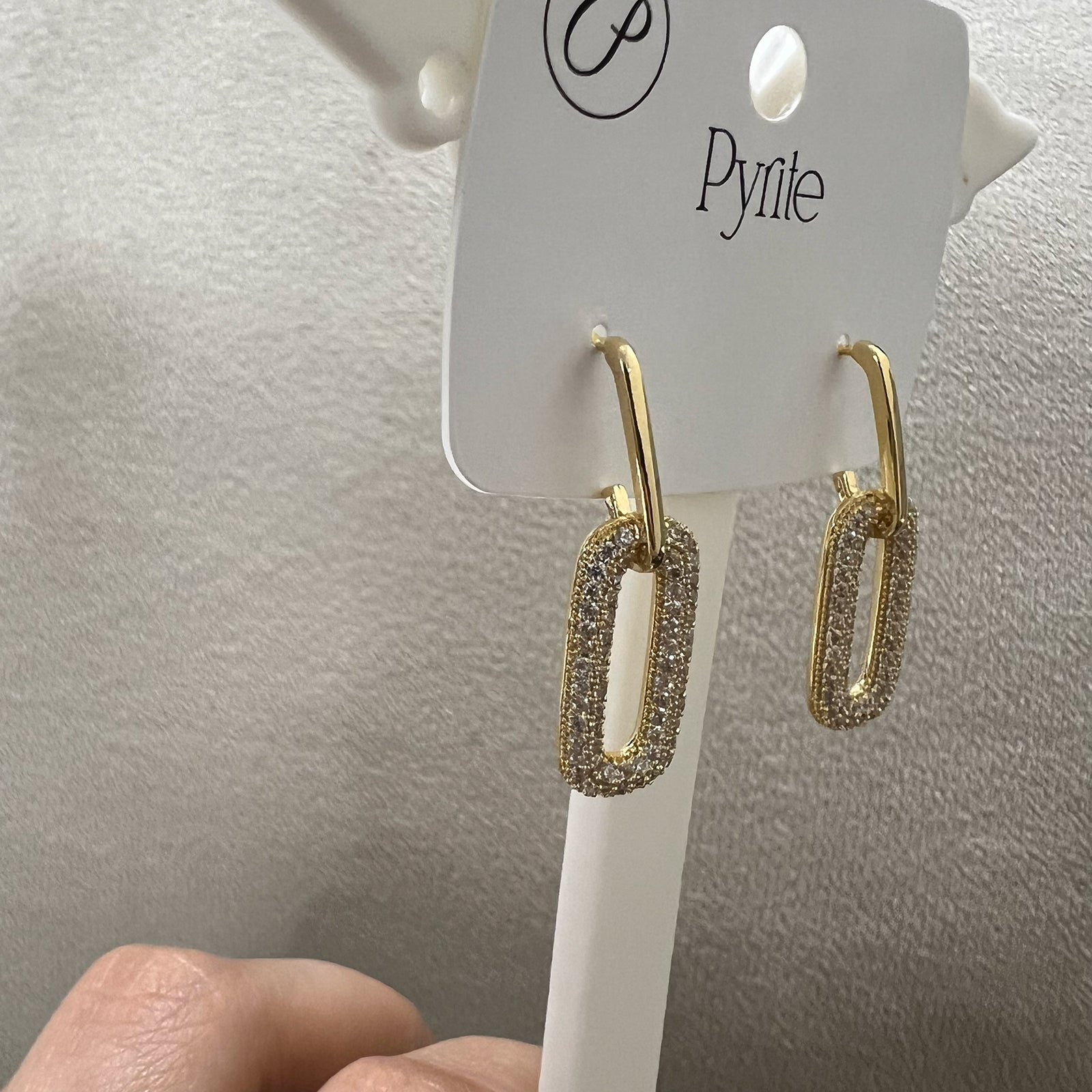 Close up view of anti-tarnish gold stainless steel earrings with sparkling stone-encrusted oval links