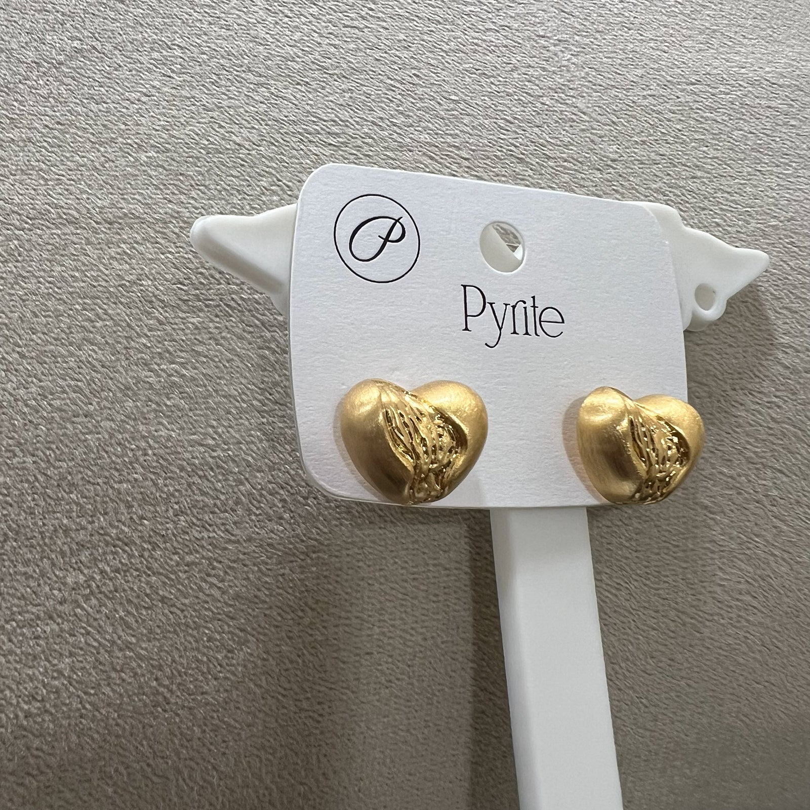 Side view of heart shaped gold finish earrings showing the unique melted texture and stainless steel construction