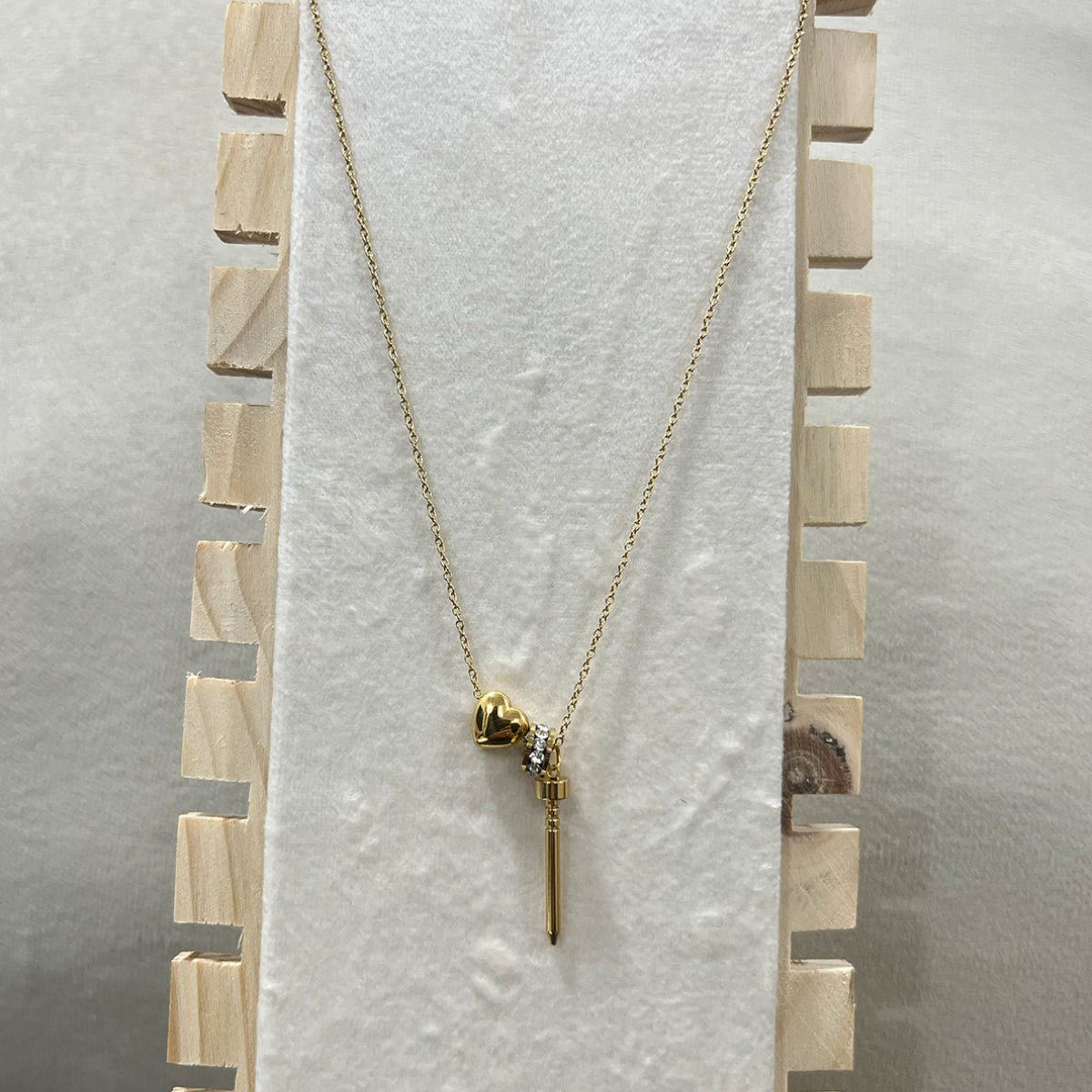 Gold necklace with a pendant on a textured white surface - zwelzy designs