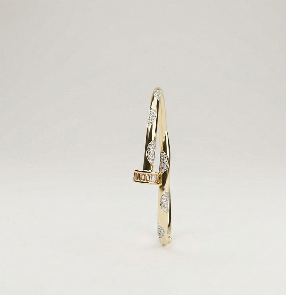 Top-down view of an embellished stainless steel nail bracelet showcasing pave stone details and a polished finish