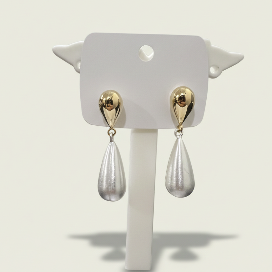 Pair of modern sculptural gold plated teardrop earrings displayed on a professional white jewelry stand