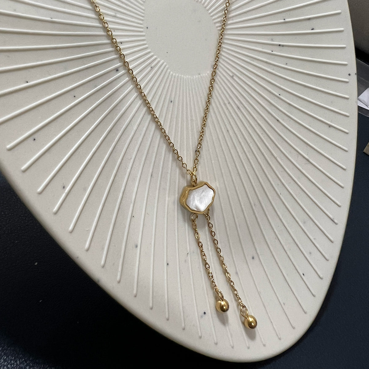 Clover-shaped gold pendant necklace with a mother-of-pearl style center and tarnish-resistant stainless steel chain