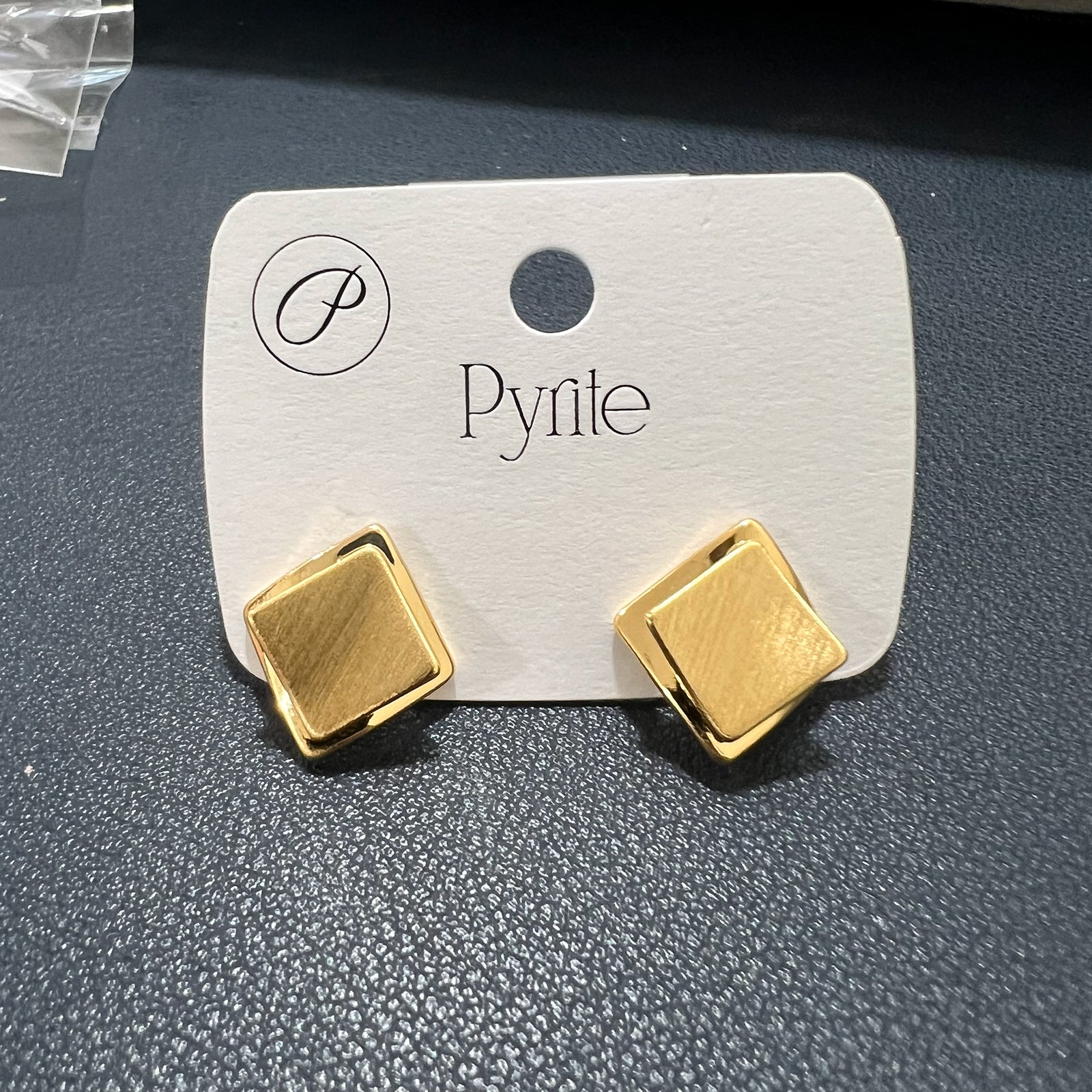 Gold plated double-layered square stud earrings with a brushed texture displayed on a white product card