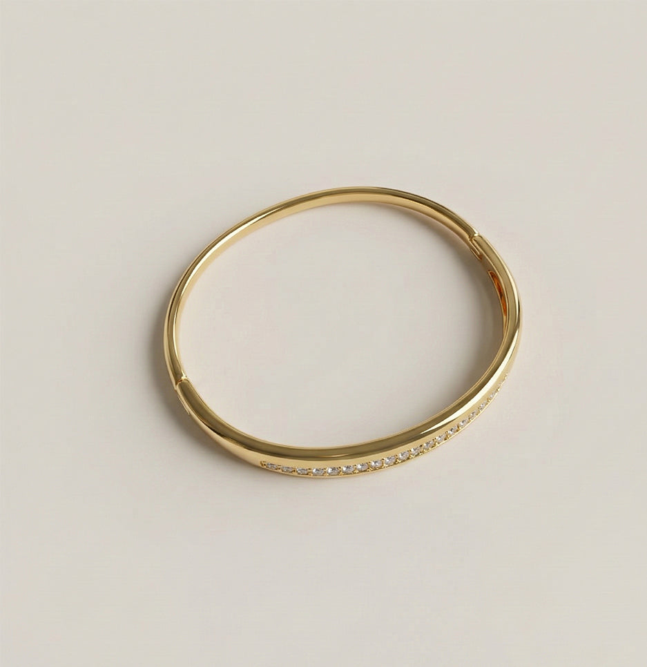 Side profile of a gold plated stainless steel bangle featuring a unique double row design with pavé stones