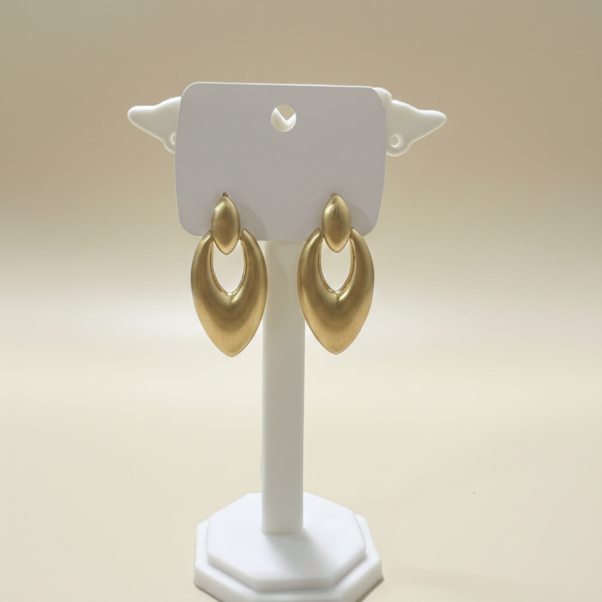 Bold matte gold open oval drop earrings showcased on a white branded jewelry card with a clean finish