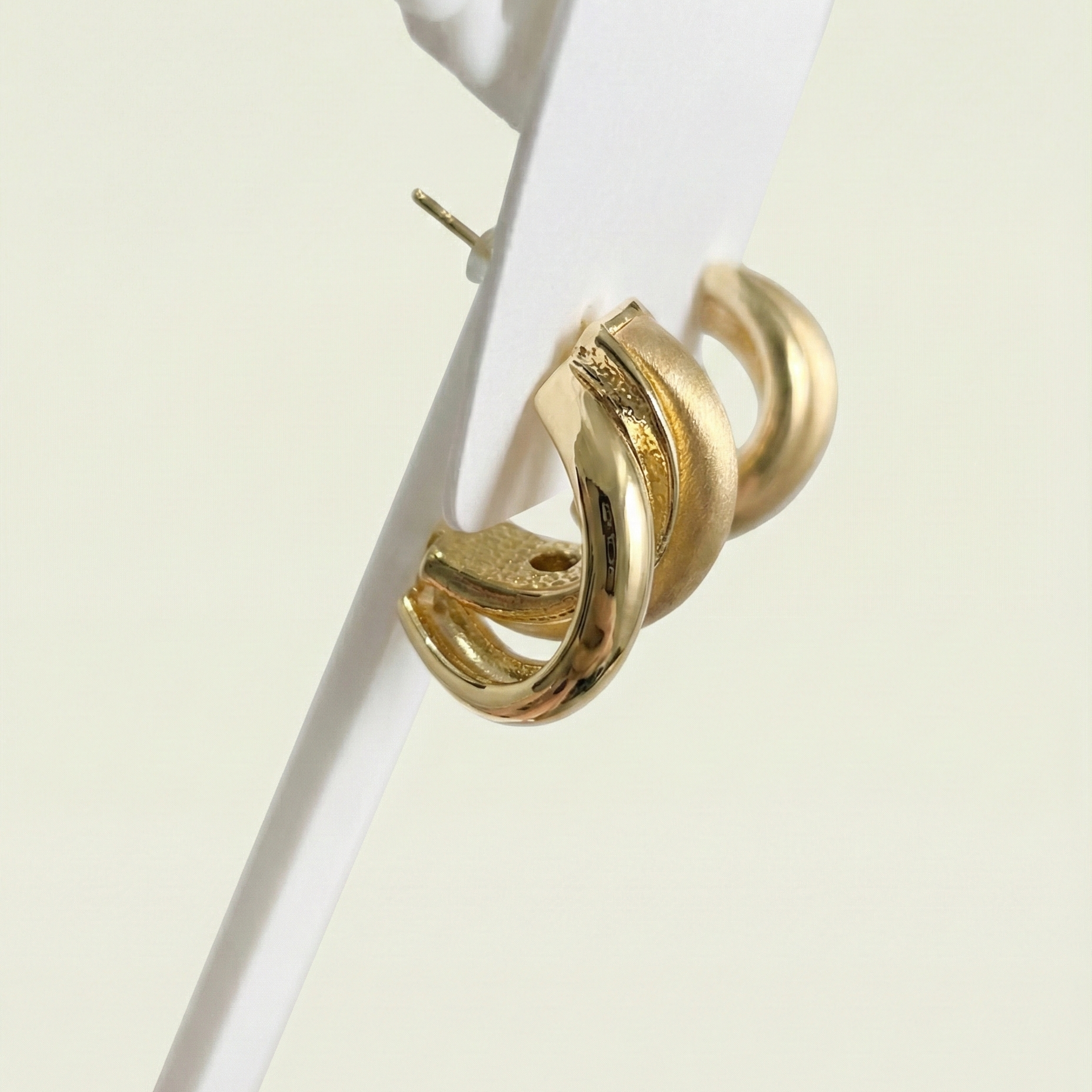 Side profile showing the secure post backing and layered ribbon design of these anti-tarnish gold earrings.
