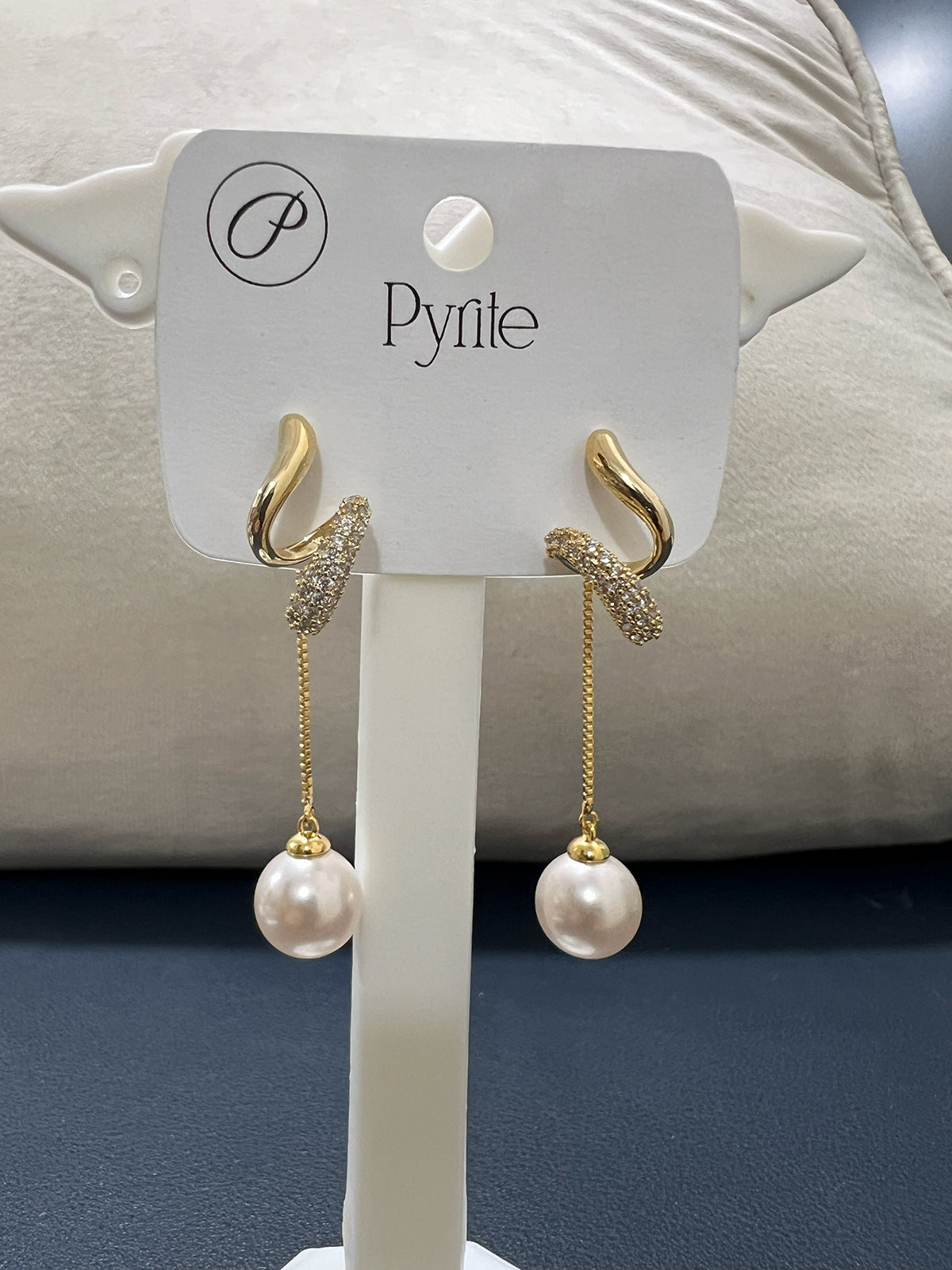 Angled view of anti-tarnish stainless steel pearl earrings highlighting the modern pavé stone and metallic finish
