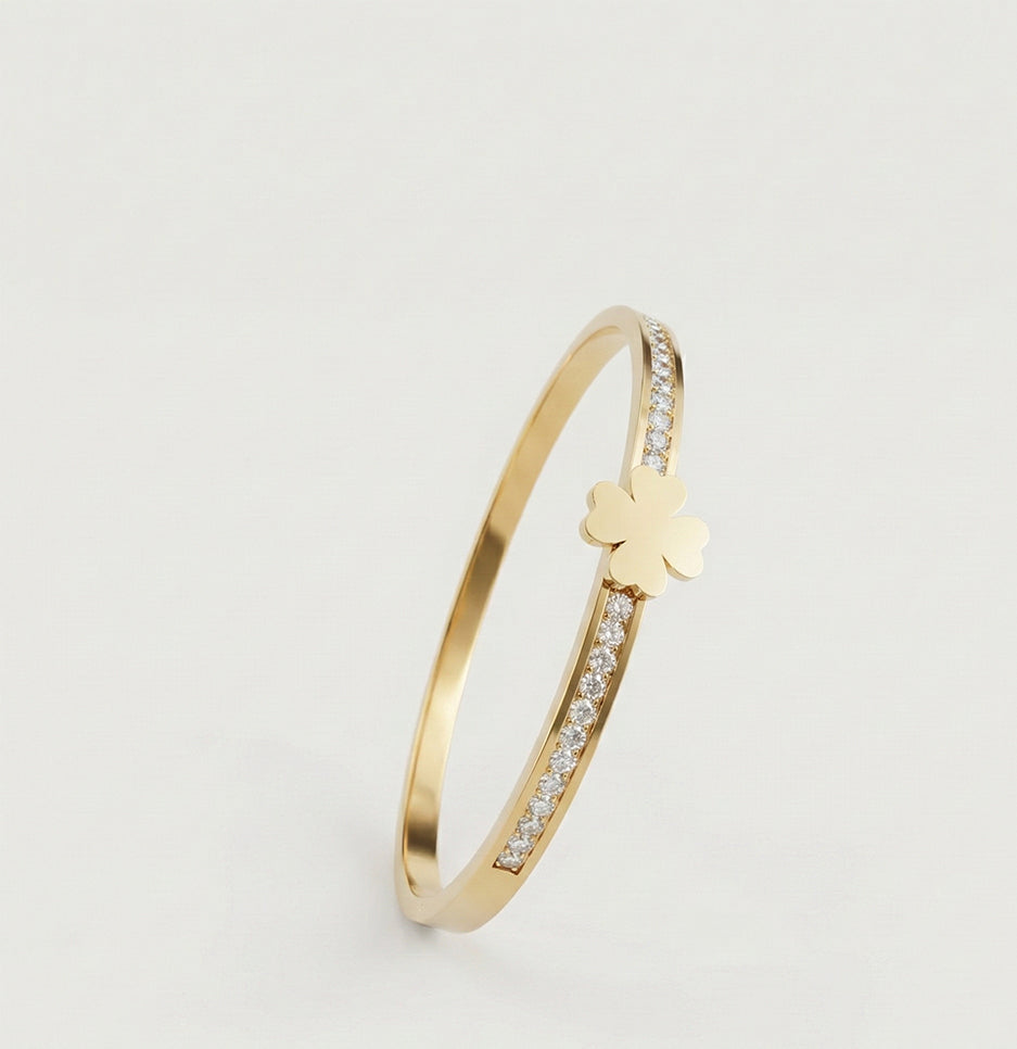Side view of an anti-tarnish stainless steel clover bracelet showing the high-polish gold finish