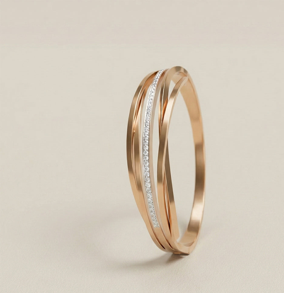 Side profile of a contemporary gold plated stainless steel bracelet highlighting its sculptural overlapping design