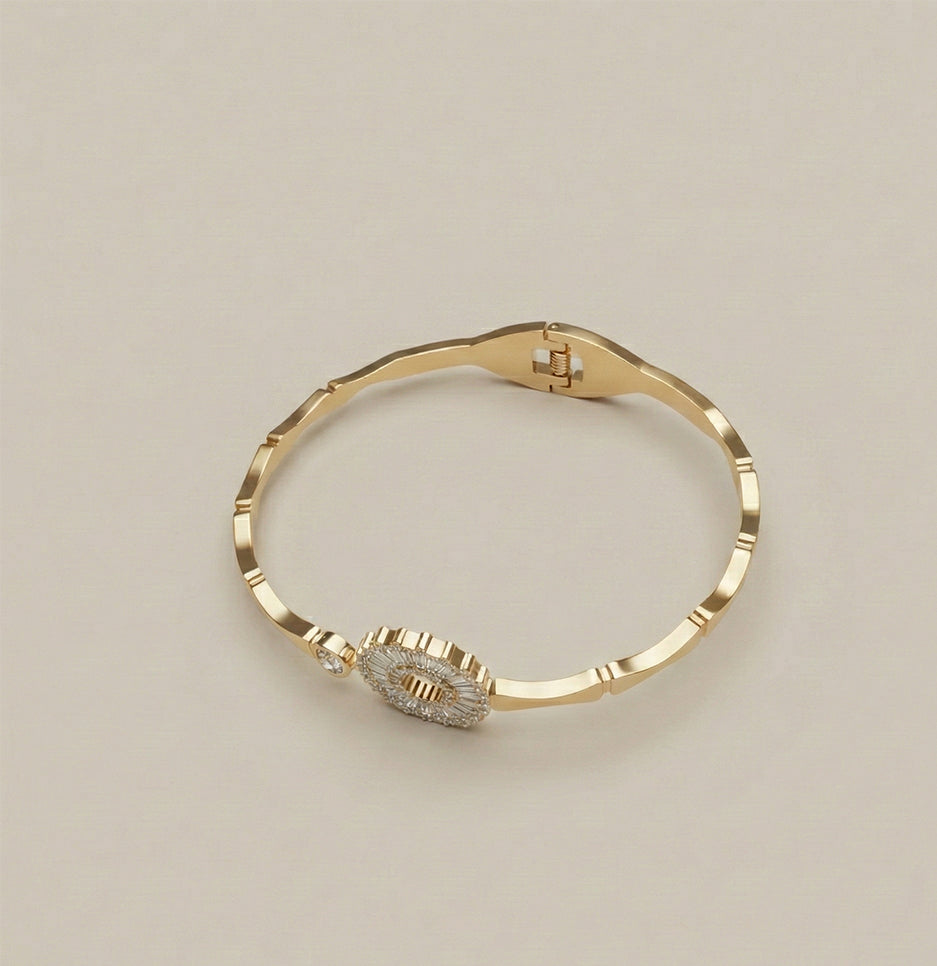 Side view of an anti-tarnish gold bangle showing the intricate baguette crystal detailing and textured metal band