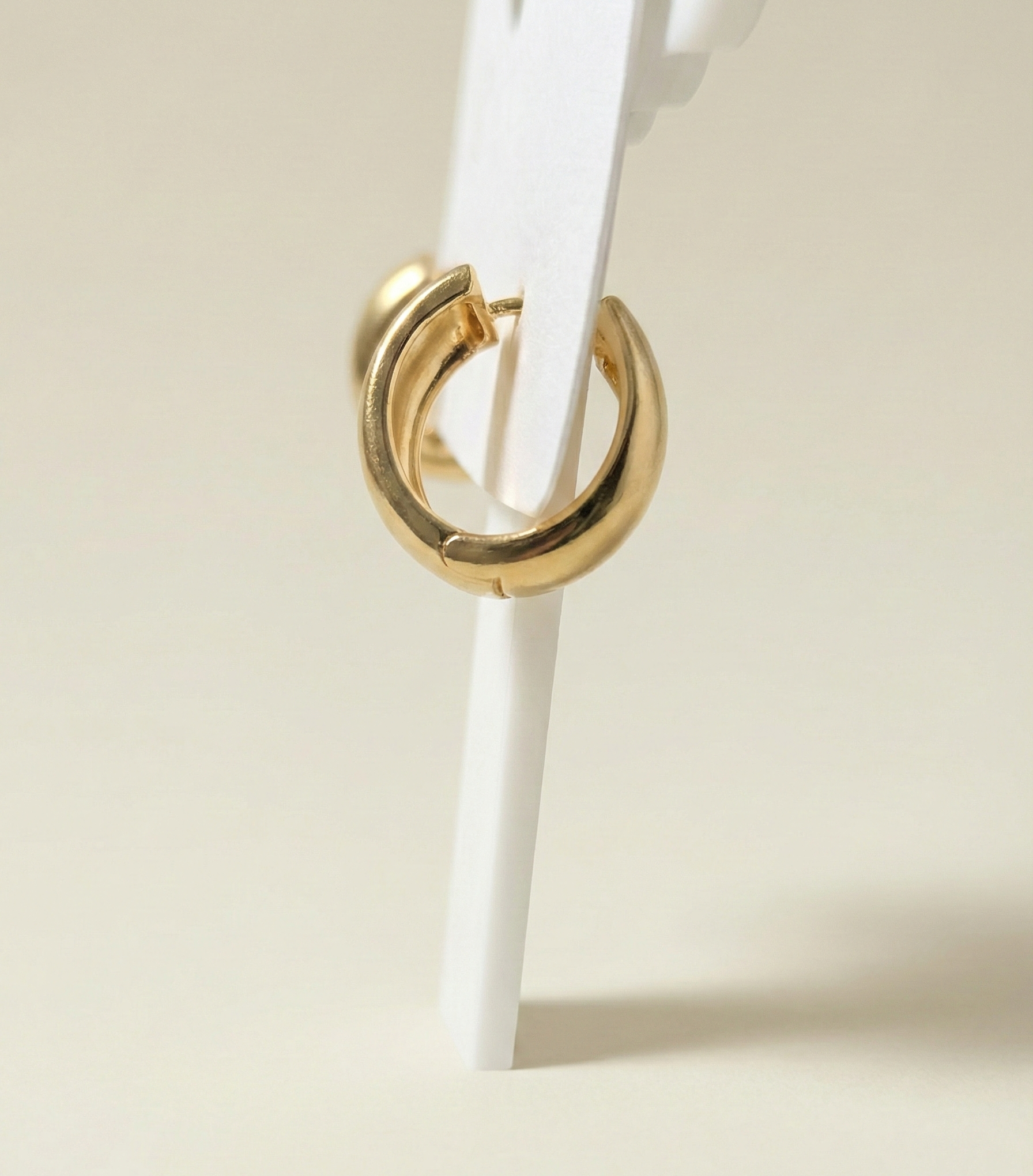 Close up side view of gold plated anti-tarnish stainless steel hoop earrings highlighting the secure hinge.