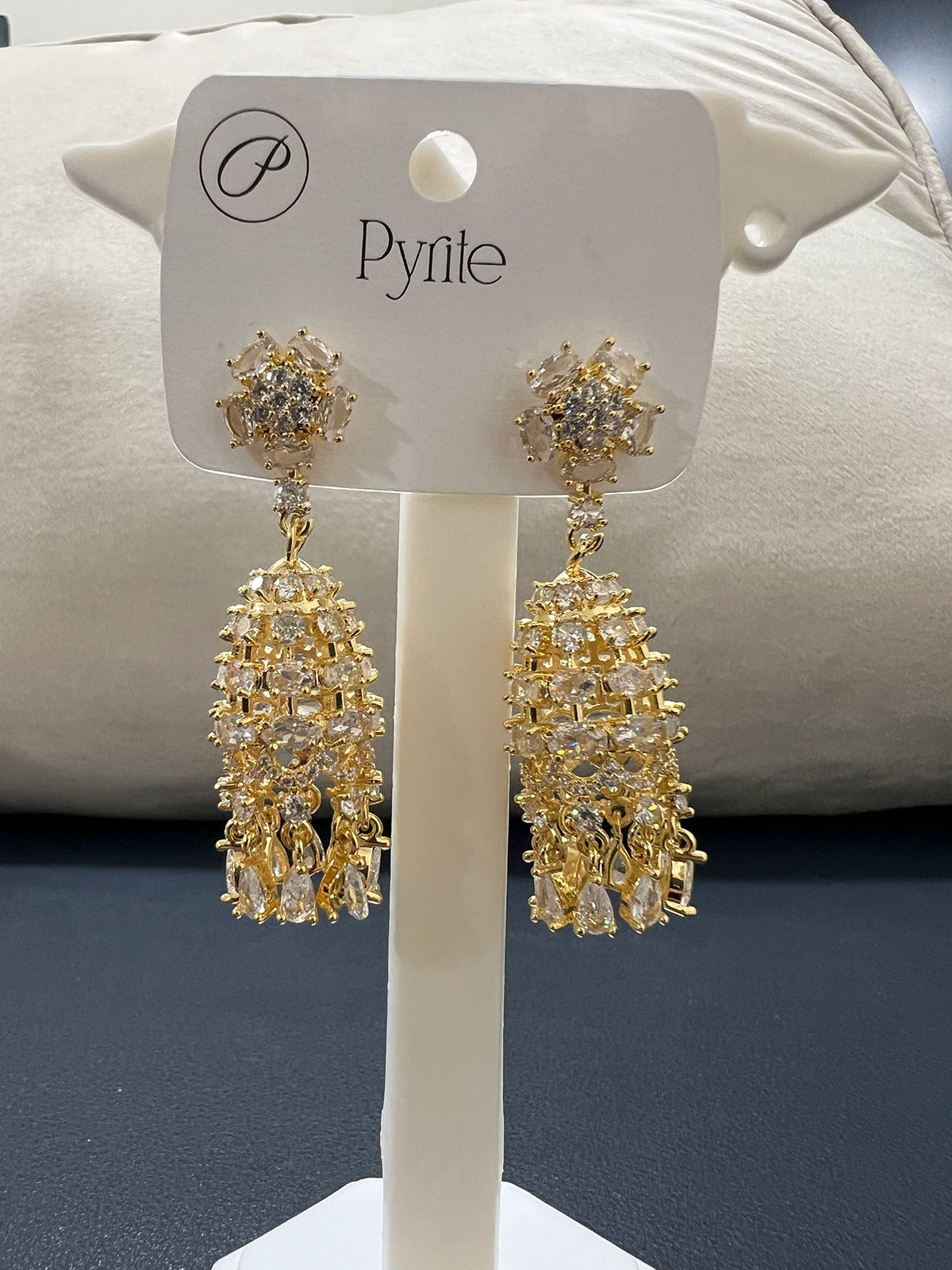 Angled side view of stainless steel gold finish traditional drop earrings showcasing the intricate stone setting.